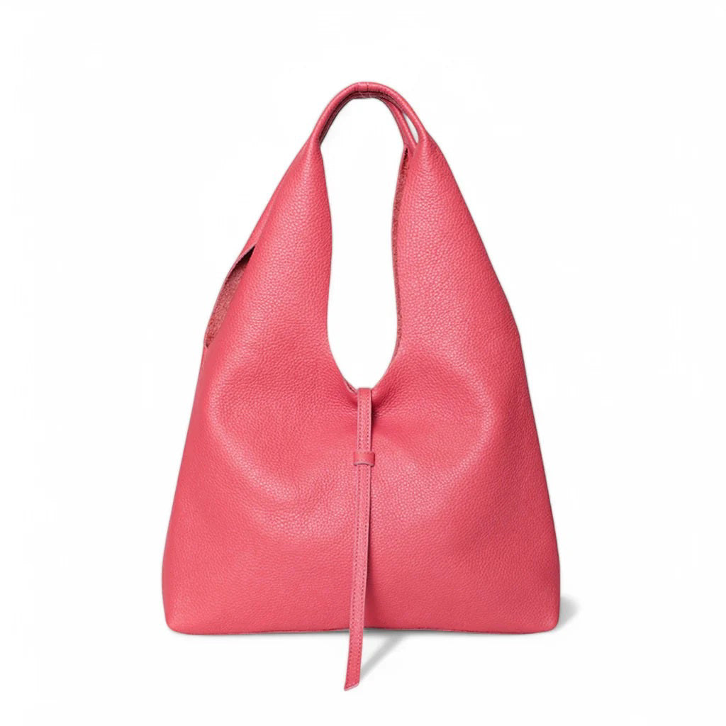 The OLIVEVE Elisabetta Shopper in pink Italian buffalo cowhide boasts a unique triangular design with a top handle and front tassel. It features soft, slightly pebbled leather and is showcased against a plain white background.