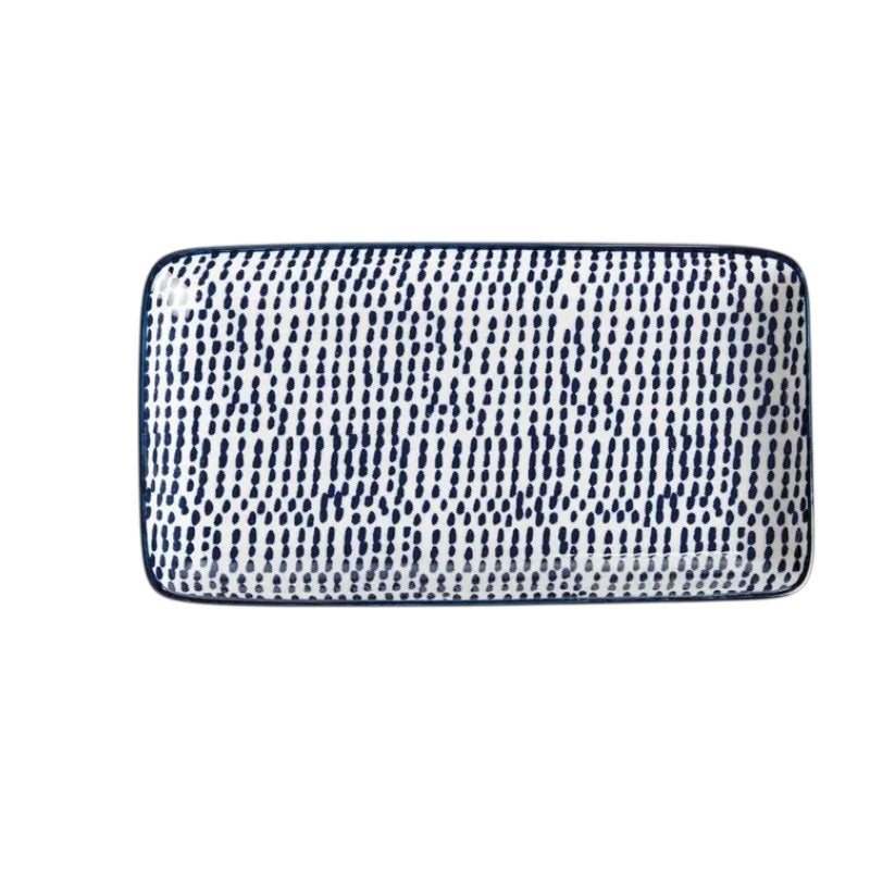 The NAPA HOME AND GARDEN Blue and White Speckled Stria Tray features a rectangular ceramic design with slightly raised edges, ideal for modern dining decor. Shown here set on a light-colored surface.