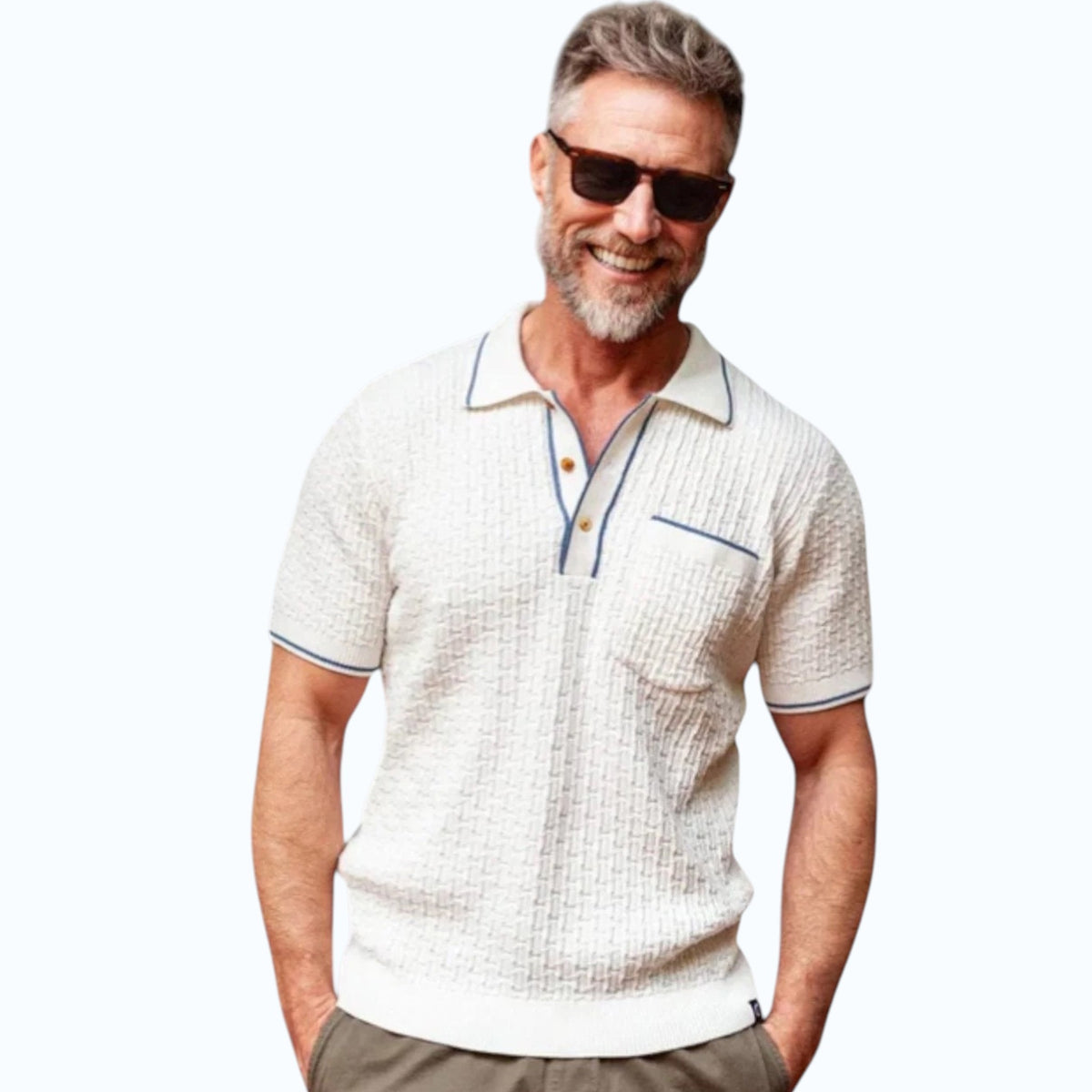 A smiling gray-haired man in sunglasses and khaki pants wears the CRIQUET Bungalow Sweater Polo in White, featuring a blue-trimmed collar and pocket, standing against a plain background.