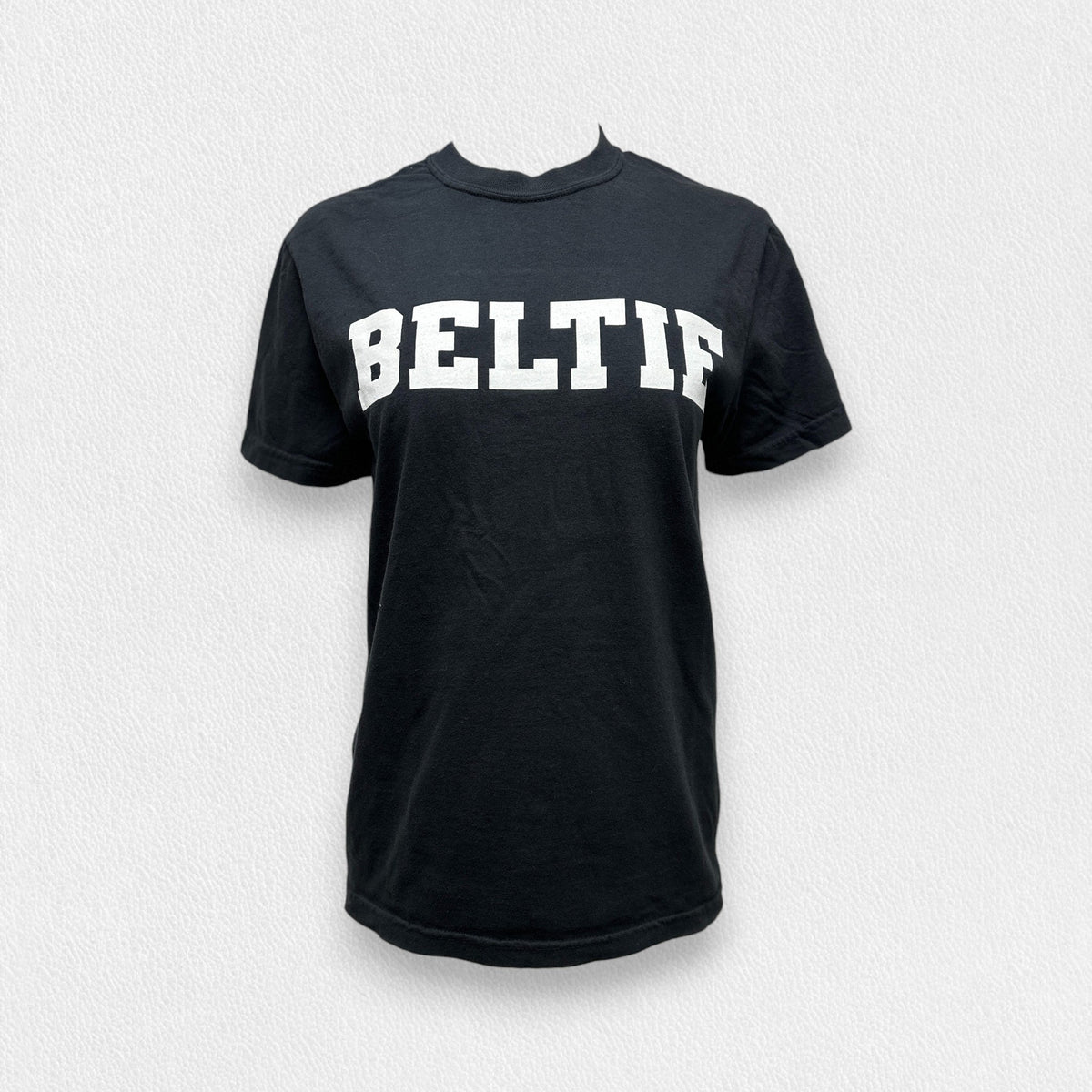 A black, unisex tee with short sleeves and a crew neck from the FEARRINGTON LIFESTYLE COLLECTION - BELTIE SHORT SLEEVE TEE SHIRT by COMFORT COLORS. The word &quot;BELTIF&quot; is printed in bold white capital letters across the chest. Made with premium fabric, this shirt is showcased on a plain light-colored background.