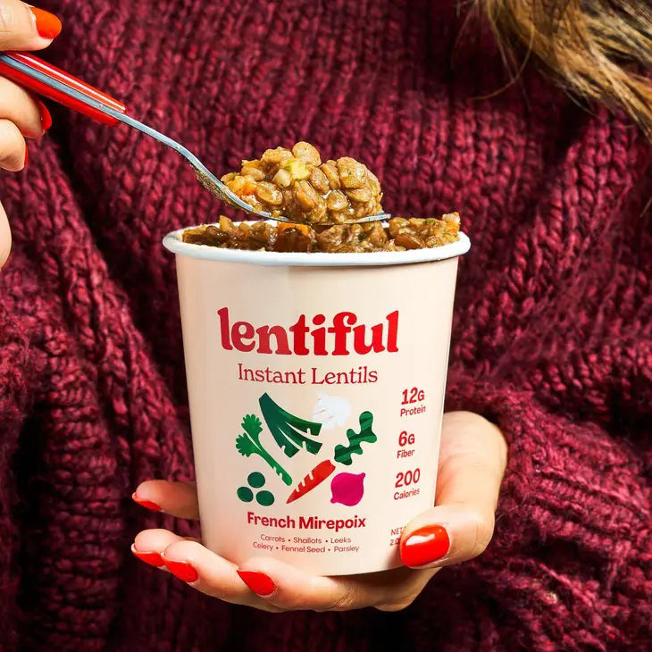 A container of LENTIFUL - FRENCH MIREPOIX INSTANT LENTILS by LENTIFUL, with a red lid and vegetable images. Each serving provides 12g protein, 6g fiber, and 200 calories. The lentils feature a Mirepoix flavor with French-style seasoning.