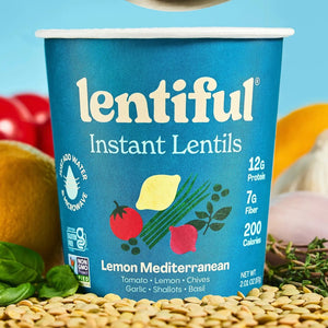 A blue container of LENTIFUL - LEMON MEDITERRANEAN INSTANT LENTILS by LENTIFUL, highlighting vibrant imagery of lemon, tomato, and herbs. Inspired by classic Greek cuisine, this plant-powered option offers 12g protein, 7g fiber, and 200 calories per serving. The label features the Non-GMO Project Verified seal, making it a nutritious pick for those seeking a Blue Zone-inspired lifestyle.
