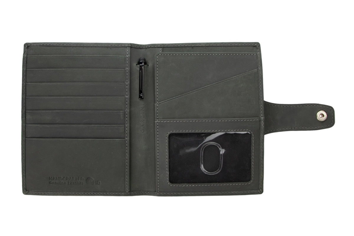 The GARZINI RFID-blocking leather passport holder in carbon black features white stitching and a round cutout for an Apple AirTag, offering secure storage and easy tracking.