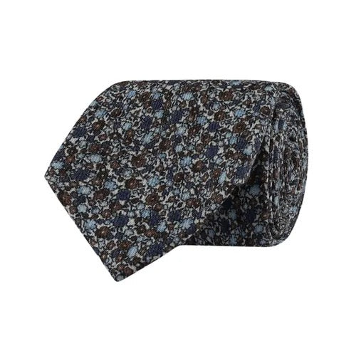 The AMANDA CHRISTENSEN - FLORAL WOOL TIE IN CREAM MELANGE showcases a refined rolled-up design, crafted from premium wool with an elegant floral pattern in blue, brown, and gray tones on a textured fabric—a sophisticated accessory for men by AMANDA CHRISTENSEN.
