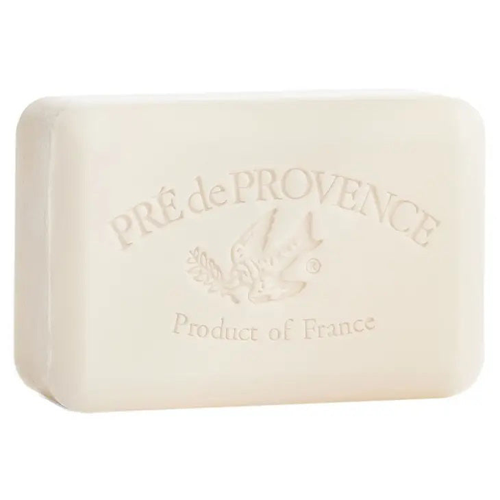 A rectangular, off-white bar of European Soaps' MILK BAR SOAP 250G, featuring a French-milled finish, embossed with "Pré de Provence" at the top, a bird holding an olive branch in the middle, and "Made in France" at the bottom. The shea-enriched soap has smooth edges and boasts a simple yet elegant design.