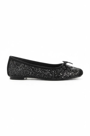 The REQINS Harmony Sequin Ballerina Flats in Noir feature black sequins, black toe caps, and small bows—bringing a touch of everyday luxury against a plain light background.