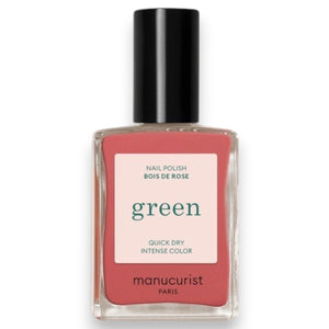 A close-up of a brush applying the smooth, glossy MANUCURIST - GREEN™ NAIL POLISH IN ROSEWOOD by MANUCURIST INC in a dusty pink rosewood shade on a flat surface, creating gentle curved lines in the polish.