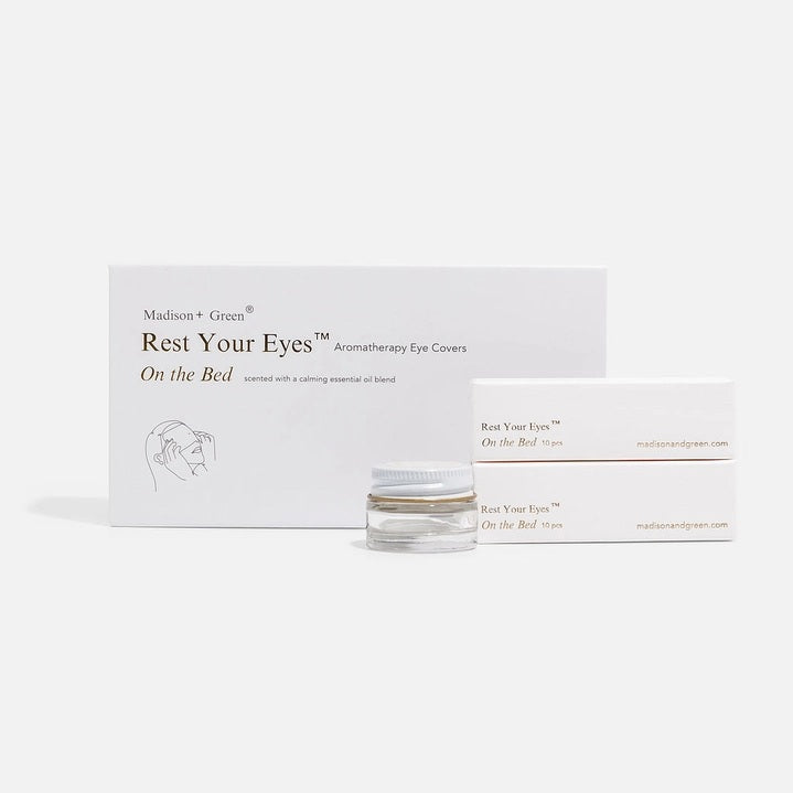 A set of MADISON GREEN - REST YOUR EYES ON THE BED relaxing eye masks and a small jar, all packaged in minimalist white with light brown text, displayed against a plain white background.