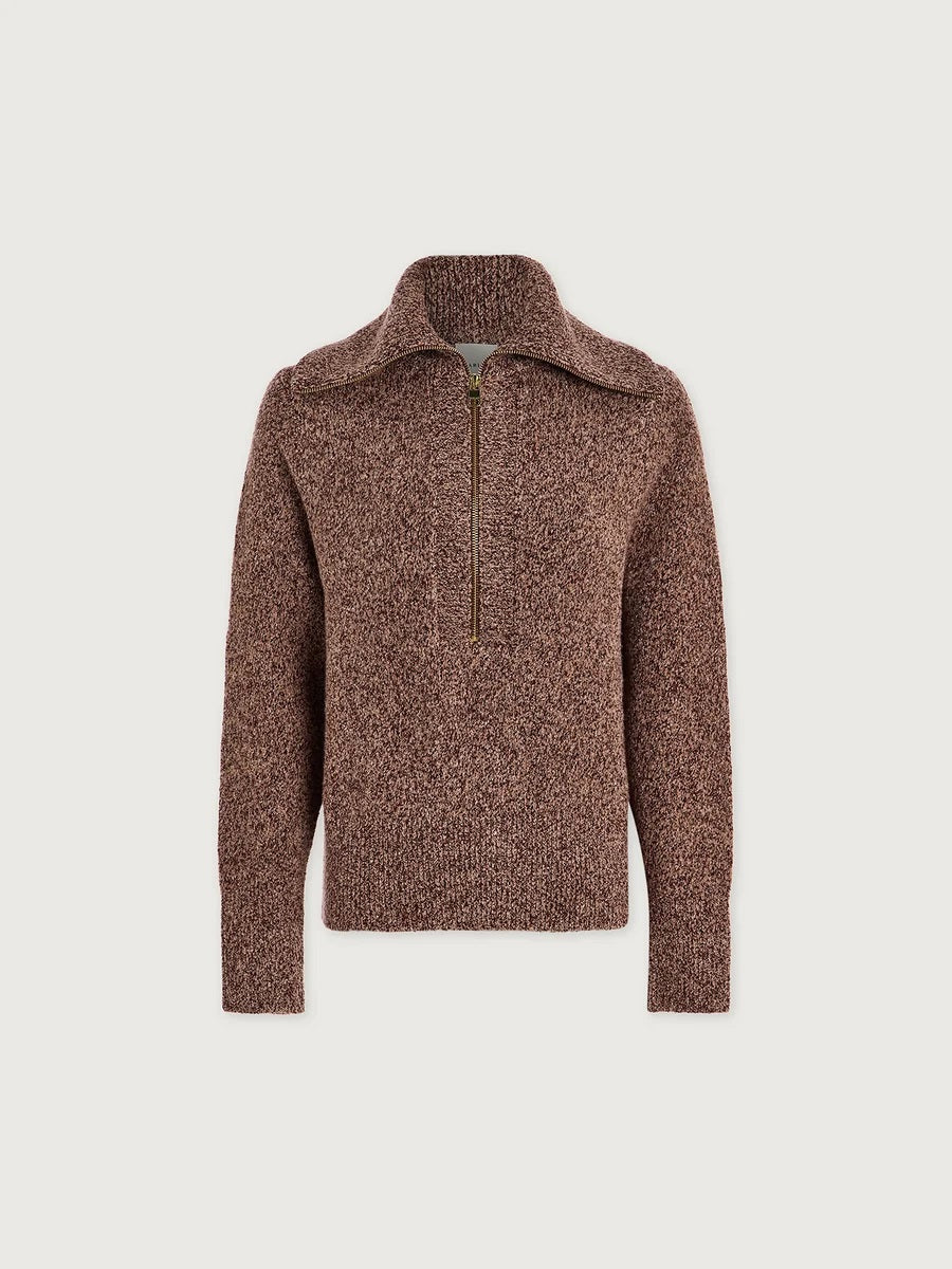 A person wearing a VARLEY - SHERIDA HALF-ZIP KNIT SWEATER IN GINGERBREAD FLECK, a brown speckled boucle yarn sweater with a collared half-zip neckline.