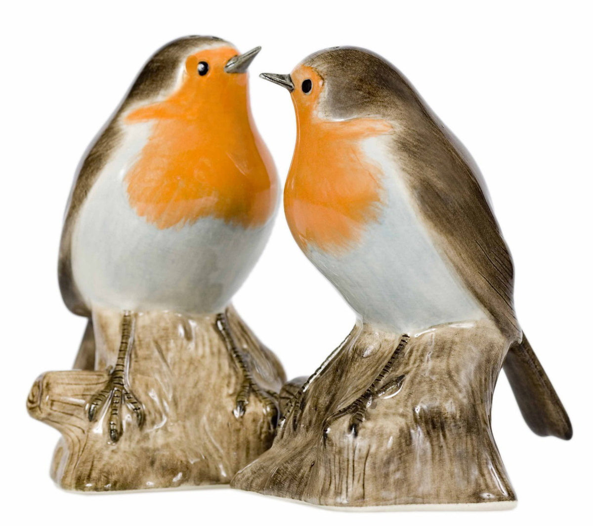 The QUAIL CERAMICS - ROBIN SALT AND PEPPER SET by QUAIL DESIGNS features two handpainted stoneware robin figurines with orange breasts and brown wings, perched on tree stumps and facing each other.