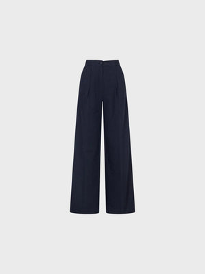 SANDRO FERRONE - PINSTRIPE TROUSER: High-waisted, wide-leg tailored pants with subtle vertical stripes, front pleats, side pockets, and a button closure by SANDRO FERRONE, shown on a plain light gray background.