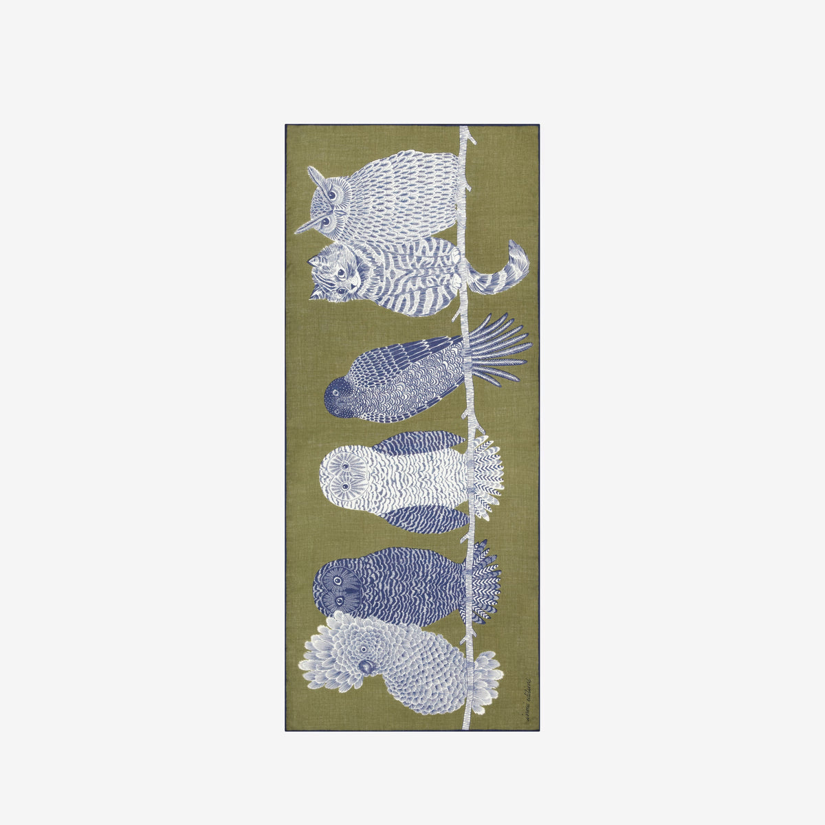 A woman with blond hair tied back wears a light gray sweater and black pants, with the INOUI EDITIONS - CHOUETTE WOOL SCARF by INOUI—an olive green wool scarf featuring a large blue and white owl design—draped over her shoulder. This hand-printed scarf, made in India, adds a vibrant touch against the plain white background.