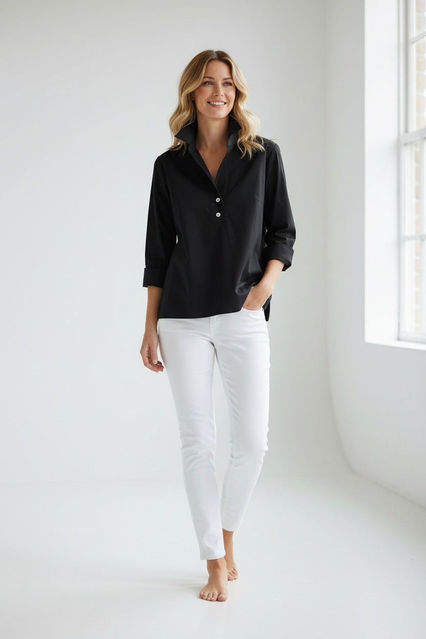 A woman with short dark hair wears the HINSON WU - AILEEN 3/4 SLEEVE POLISHED COTTON SHIRT, styled with white pants, standing against a plain light background.
