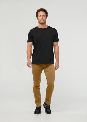 Close-up of the back of a person wearing the DUER No Sweat Straight Pants in Caramel, featuring stitched back pockets and a black DUER brand label on the waistband, crafted from DUER’s innovative No Sweat fabric for exceptional comfort.