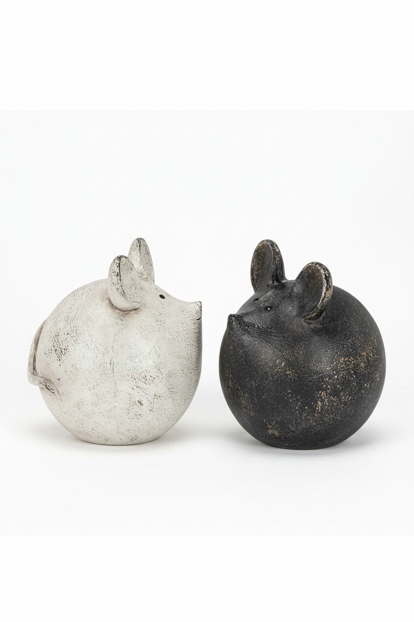 Two spherical, antique white and black resin BALL MOUSE figurines facing each other.