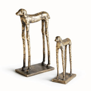 The NAPA HOME AND GARDEN - HOUND DOG SCULPTURES feature two metallic, abstract hounds with elongated legs on rectangular bases (one taller). Modern desk decor or a gold bookshelf accent by NAPA HOME AND GARDEN.