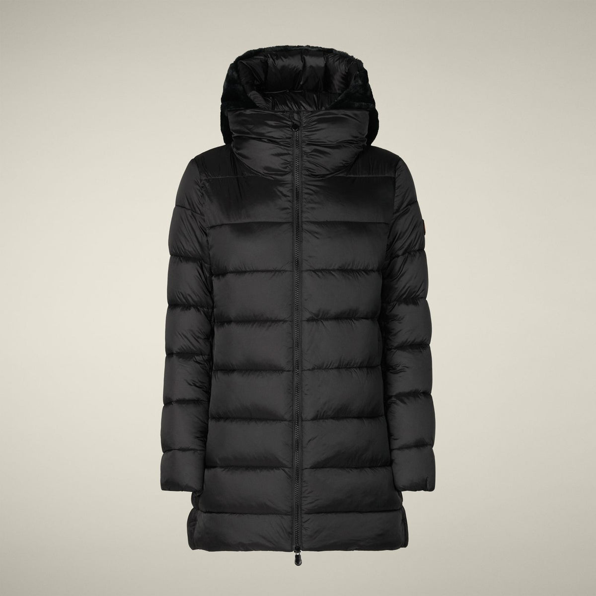 A woman stands against a light background wearing the SAVE THE DUCK - MATILDA PUFFER COAT, white leggings, and black boots. She faces forward with her hands by her sides and maintains a neutral expression.