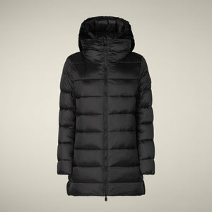 A woman stands against a light background wearing the SAVE THE DUCK - MATILDA PUFFER COAT, white leggings, and black boots. She faces forward with her hands by her sides and maintains a neutral expression.