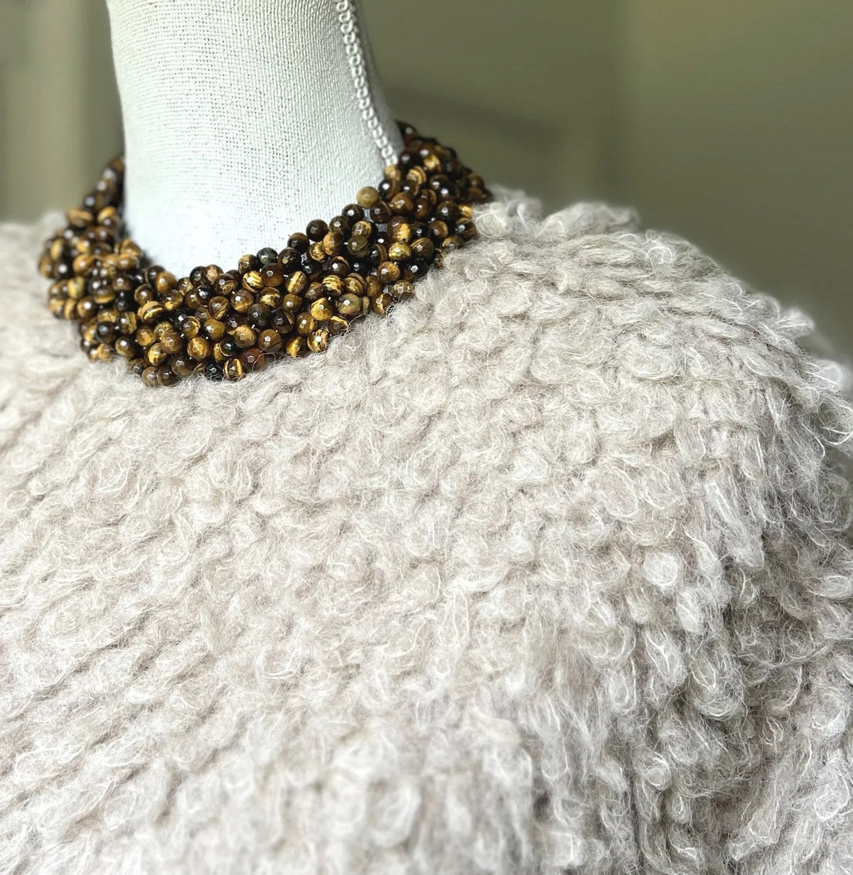 The ANN LIGHTFOOT Tiger Eye Braided Collier Necklace features multiple strands of polished brown beads in varied shades, twisted together with a glossy finish and finished with a sleek sterling silver clasp.