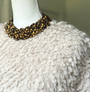 The ANN LIGHTFOOT Tiger Eye Braided Collier Necklace features multiple strands of polished brown beads in varied shades, twisted together with a glossy finish and finished with a sleek sterling silver clasp.