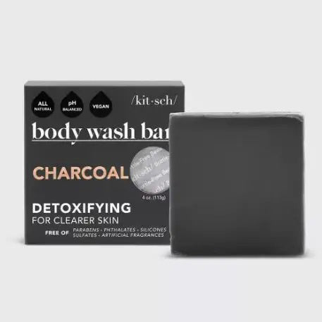 The KITSCH - CHARCOAL DETOXIFYING BODY WASH BAR, a black square solid soap on a matching box, is gentle, vegan, and all-natural. Detoxify pores and refresh your skin with this 4 oz. (113g) zero-waste treat while embracing an eco-friendly lifestyle.