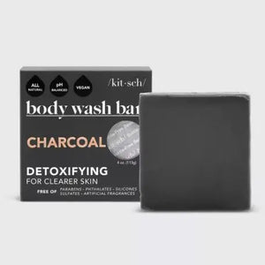 The KITSCH - CHARCOAL DETOXIFYING BODY WASH BAR, a black square solid soap on a matching box, is gentle, vegan, and all-natural. Detoxify pores and refresh your skin with this 4 oz. (113g) zero-waste treat while embracing an eco-friendly lifestyle.