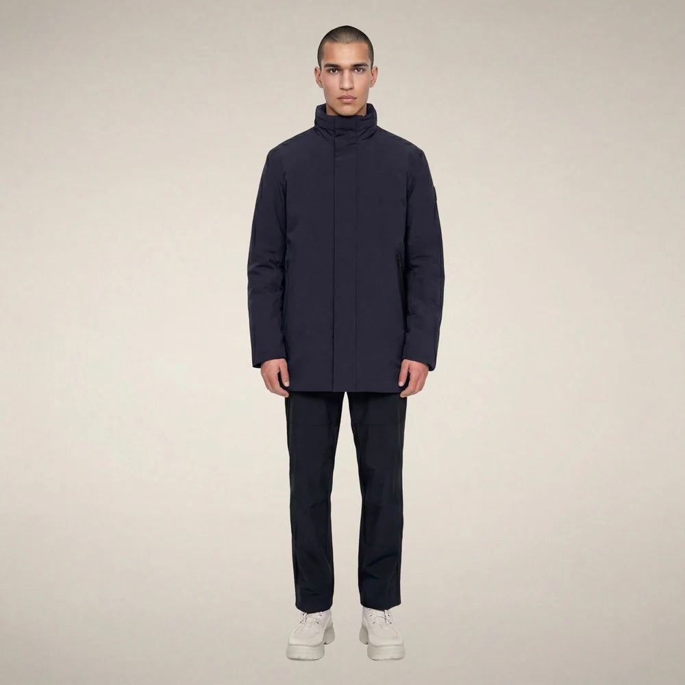 A man wears a dark blue SAVE THE DUCK - BLAISE JACKET IN BLUE BLACK with a high neck and a zippered chest pocket.
