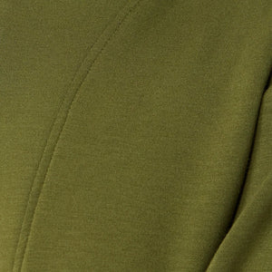 A woman wears a SOFTIES - DREAMTECH BOAT NECK WITH PINTUCK PANT SET in olive green, featuring a long-sleeve boat neck top and matching wide-leg pintuck pants.
