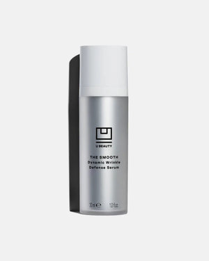 A silver 30ml bottle of U BEAUTY THE SMOOTH DYNAMIC WRINKLE DEFENSE SERUM with white cap and black logo, shown on a light background—an advanced serum designed to visibly reduce fine lines for effective anti-aging care.
