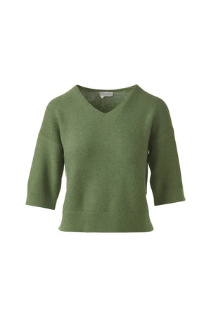 A woman with straight brown hair wears the KINROSS CASHMERE Garter Easy Vee Neck Cotton Sweater in bright pink, featuring a relaxed fit and elbow-length sleeves, paired with white pants against a plain white background.