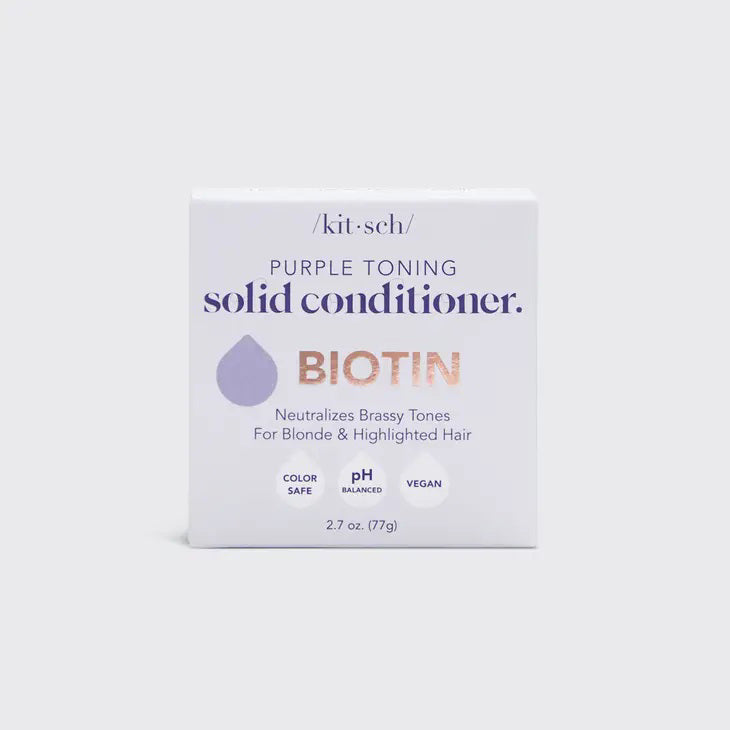 A KITSCH Purple Toning Solid Conditioner Bar sits on its packaging, which states it's formulated with Biotin for blonde and highlighted hair, neutralizing brassiness. The labels affirm it's color safe, pH balanced, and vegan.