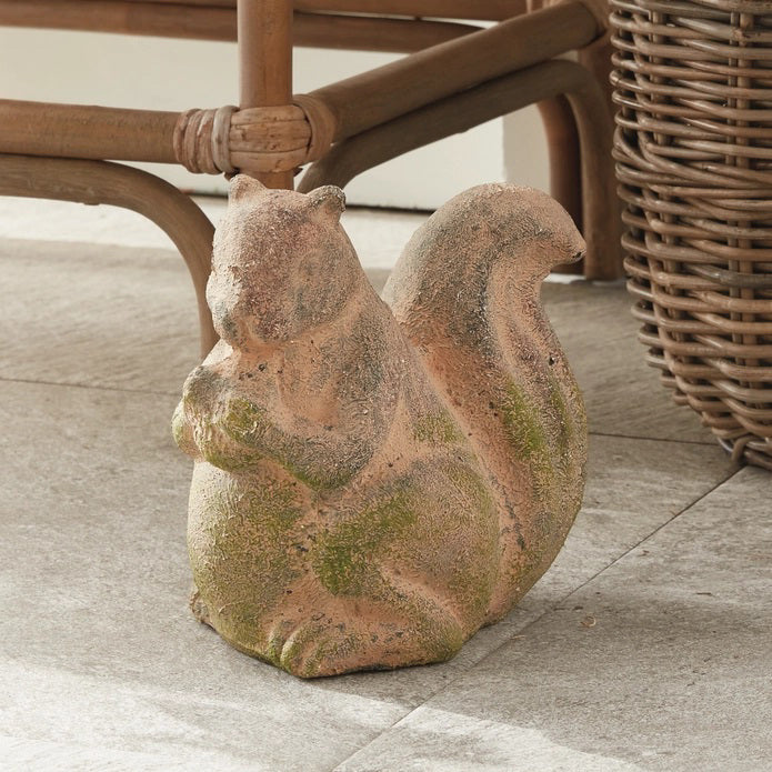 The NAPA HOME AND GARDEN - WEATHERED GARDEN SQUIRREL adds charm to your decor with its weathered look, bushy tail, and detailed design, perfect for placing beside curated furniture indoors or outdoors.