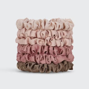 A set of six eco-friendly KITSCH - ULTRA PETITE SATIN SCRUNCHIES in elegant pink and beige shades is displayed on a branded card. These scrunchies not only enhance your style but also help reduce hair damage, making them both chic and gentle on your hair.