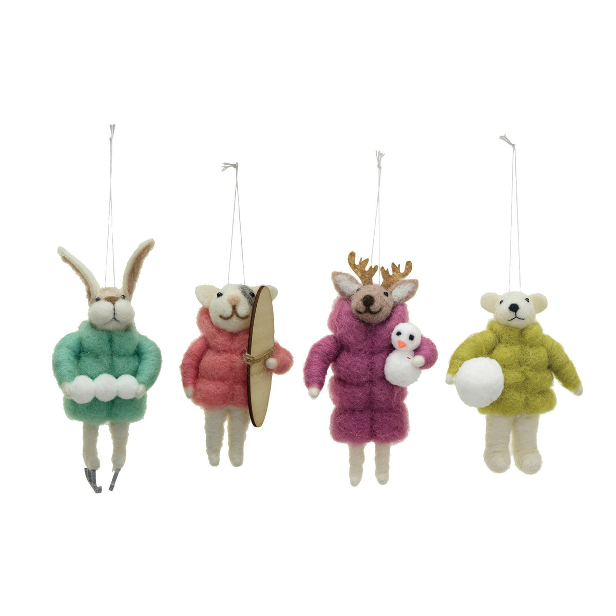 Displayed on a textured, glittered surface are four small, multi-color ornaments from CREATIVE COOP&#39;s collection. These handmade wool felt animal creations include a bear, cat, rabbit, and deer dressed in vibrant winter coats of yellow, pink, green, and purple. The charming deer features a tiny snowman.