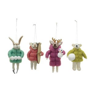 Displayed on a textured, glittered surface are four small, multi-color ornaments from CREATIVE COOP's collection. These handmade wool felt animal creations include a bear, cat, rabbit, and deer dressed in vibrant winter coats of yellow, pink, green, and purple. The charming deer features a tiny snowman.