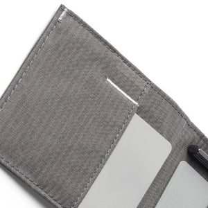 The ALLETT Sport Wallet in RFID-blocking charcoal grey nylon features subtle grid lines and a small white triangular logo on the lower right, shown closed on a white background.