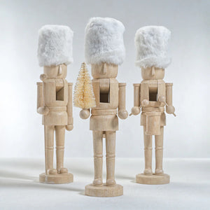 ZODAX RESIN NUTCRACKERS WITH FUR HATS: Three figurines in a natural finish, one with a bottle brush tree, another with a staff, and the third at its sides—perfect for home decor.