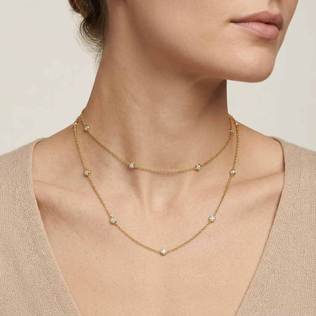 The ELLA STEIN - DOT TO DOT NECKLACE by ELLA STEIN is a delicate gold plated piece featuring a fine chain adorned with three evenly spaced small round natural diamonds, beautifully showcased on a white background. This elegant necklace brings a touch of sophistication to any outfit.