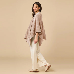 A woman wearing a black SOFTIES - SOLID RIB MARSHMALLOW SHAWL over a grey top and white trousers.