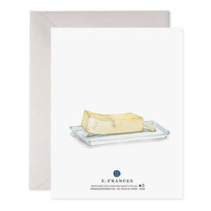 The E. Frances Paper "More Than Butter" greeting card features a whimsical watercolor of a butter stick with tiny arms and legs. "LOVE YOU MORE THAN" text adorns the top, and it comes with a light gray envelope, proudly made in the USA.