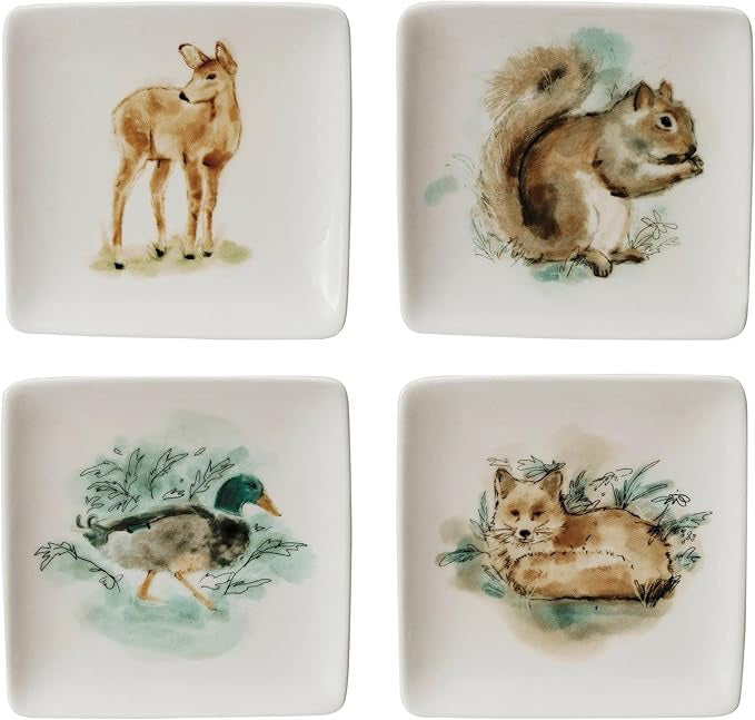 The CREATIVE COOP STONEWARE DISH WITH ANIMALS set includes four square plates, each with watercolor animal illustrations—a deer, squirrel, mallard duck, and fox—on white backgrounds with greenery accents.