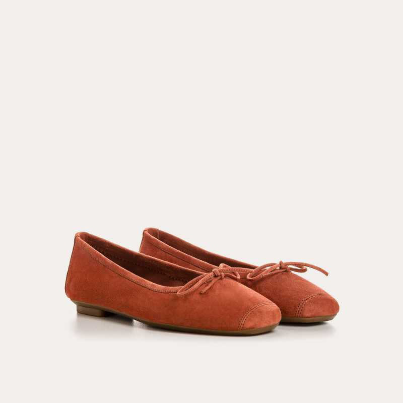 The REQINS - HARMONY Suede Ballerina Flat in Brique is shown in soft suede goatskin with a small bow on the toe, displayed side view against a plain white background.