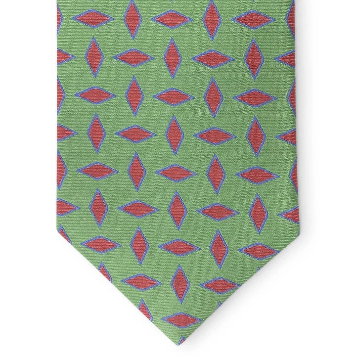 The PETER-BLAIR Archer woven silk tie in green by BIRD DOG BAY features a repeating pattern of red and blue leaf designs, rolled with the wide end facing forward.