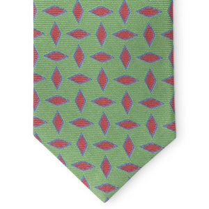 The PETER-BLAIR Archer woven silk tie in green by BIRD DOG BAY features a repeating pattern of red and blue leaf designs, rolled with the wide end facing forward.