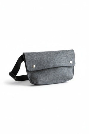 The WOOLBERRY - FELTED WOOL BELT BAG by WOOLBERRY is a small green belt bag crafted from felted wool, featuring a flap secured by two silver snap buttons, and is displayed against a white background.