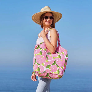 The ROCKFLOWERPAPER POPPY PAPAVER BUCKET BAG is a spacious cotton canvas tote with large pink flowers and green leaves on white. Featuring two handles, this stylish bag by ROCKFLOWERPAPER is perfect for everyday shopping or casual use.