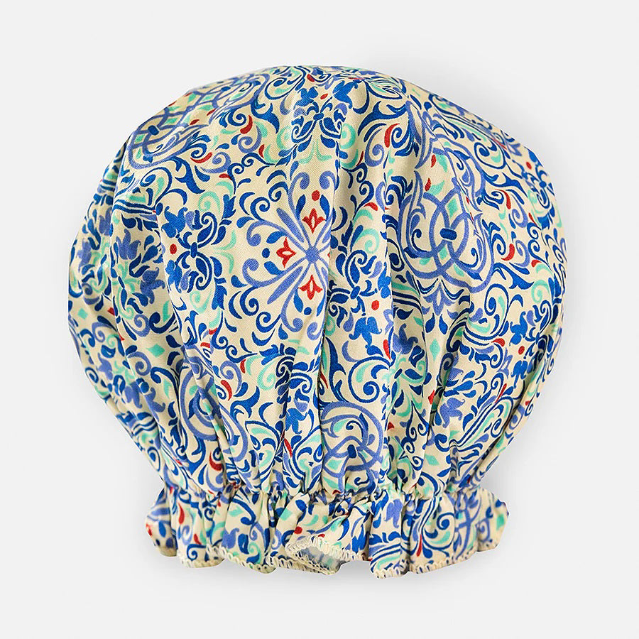 The BATH ACCESSORIES COMPANY&#39;s BOUFFANT SHOWER CAP - MORROCAN is a high-quality, waterproof cap with intricate floral and geometric patterns in blue, green, and red on a white background. It features an elastic-gathered bottom for a puffed shape.