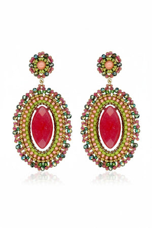 The MIGUEL ASES - CRYSTAL MIYUKI DROP EARRINGS by MIGUEL ASES, INC. are handcrafted, oval-shaped dangle earrings featuring a central red stone and intricate beadwork in red, green, and gold. An ornate design on top complements the vibrant colors of these statement pieces.