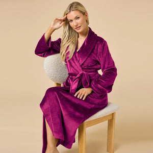 A person wearing a beige SOFTIES - SERENITY WRAP ROBE featuring a wrap silhouette with a tie waist and side pockets.