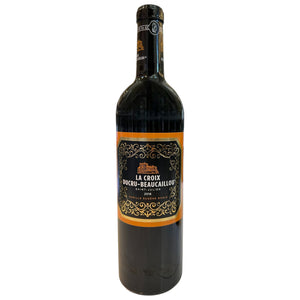 A bottle of CHÂTEAU DUCRU-BEAUCAILLOU ‘LA CROIX’ 2018 from WINE: MONSIEUR TOUTON, adorned with an ornate gold and black label, stands upright against a white background. This refined 2018 vintage highlights the esteemed character of the Saint-Julien appellation.